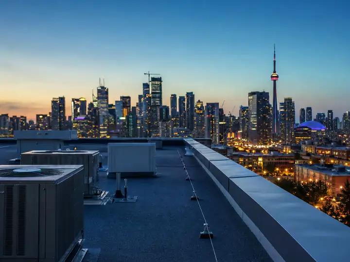 A finished flat commercial roof at dusk with the city skyline behind it